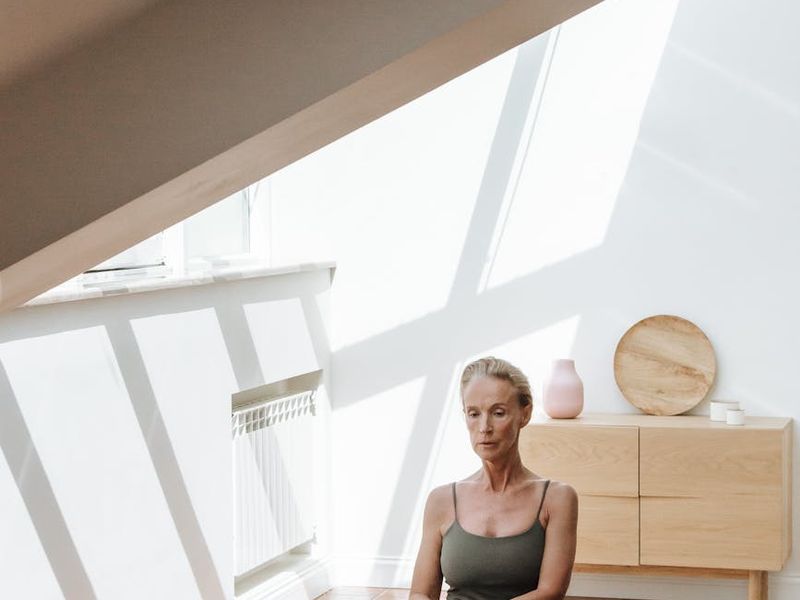 Person practicing yoga in a bright minimalistic studio room.